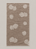 Brown bath towel with repeated white floral motifs measuring 72 x 136 cm