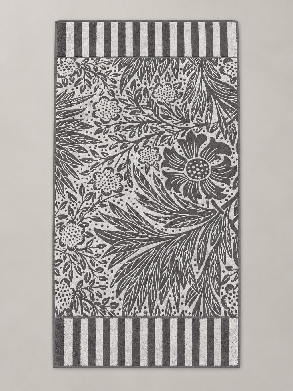 Charcoal gray and white botanical floral bath towel with striped borders measuring 70 x 146 cm
