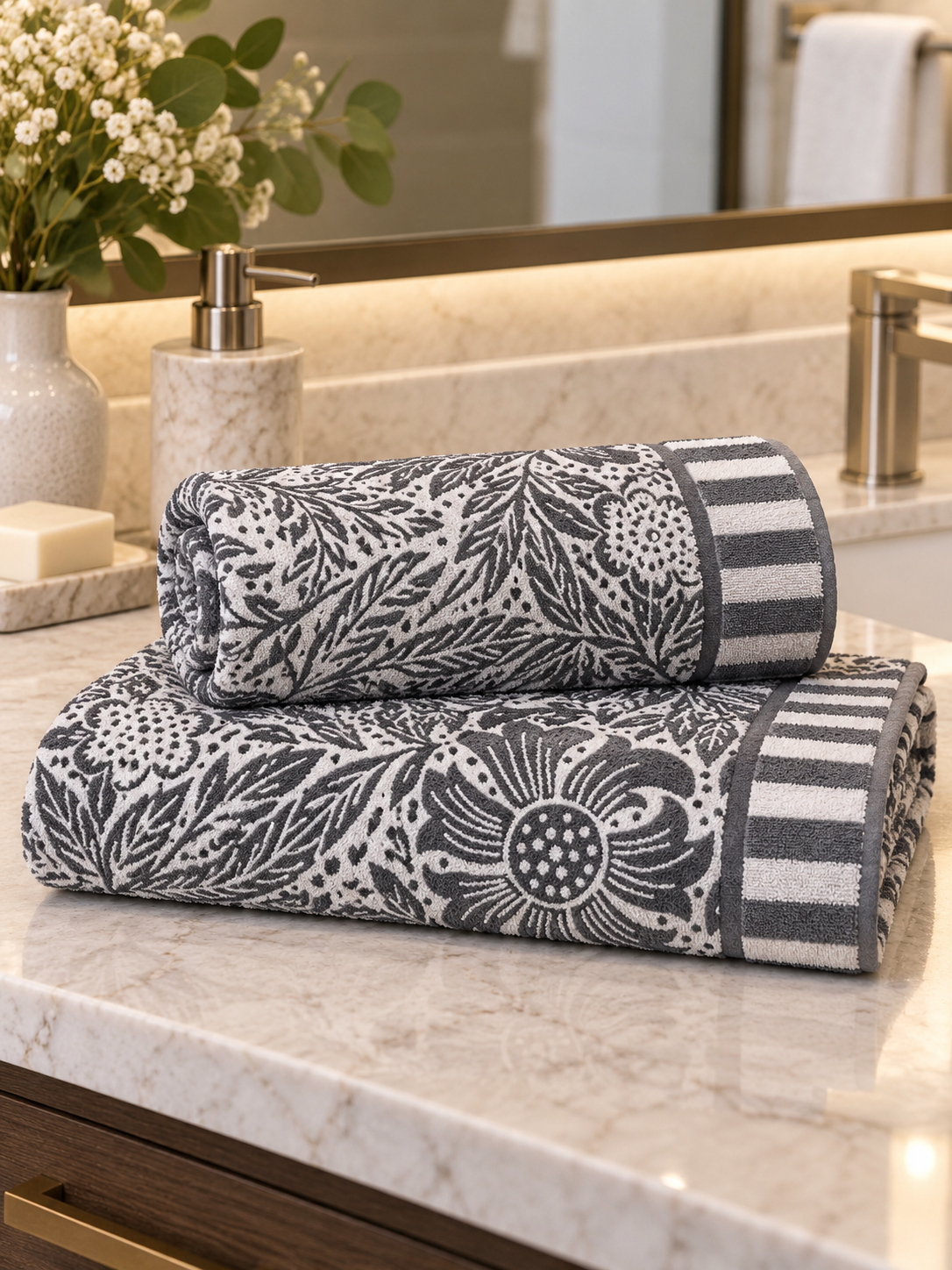 Charcoal gray and white botanical floral bath towel styled in a premium hotel bathroom