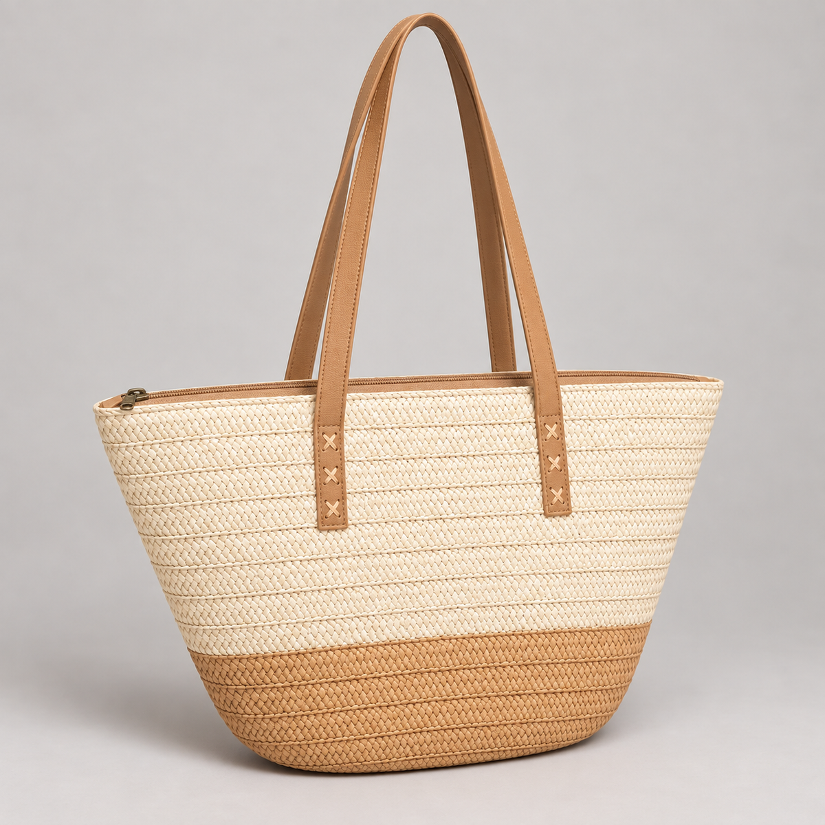 Cream and tan tapered woven zip tote in three-quarter view