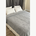 Grey cotton terry bedspread draped over a white bed in a luxury bedroom setting