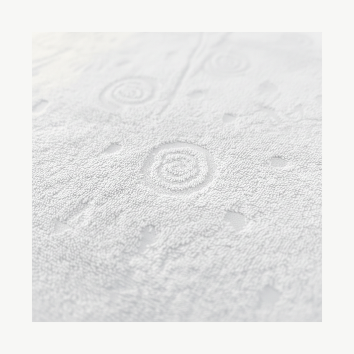 Close-up of raised shell jacquard pattern on white cotton terry cloth fabric