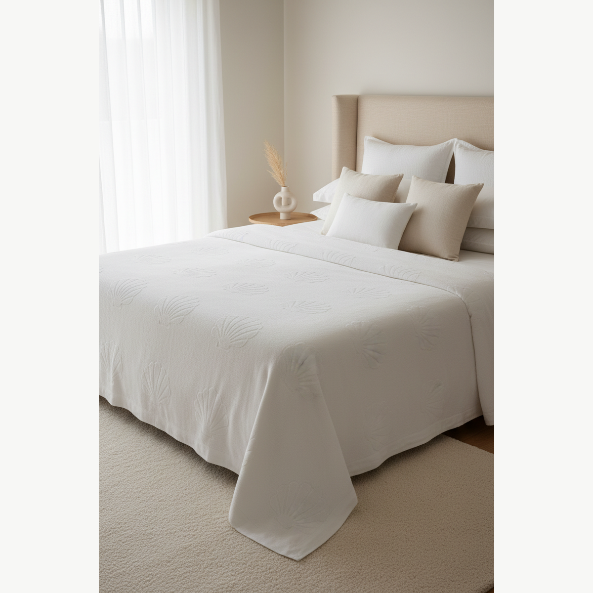 Cream cotton terry bedspread draped over a white bed in a luxury bedroom setting