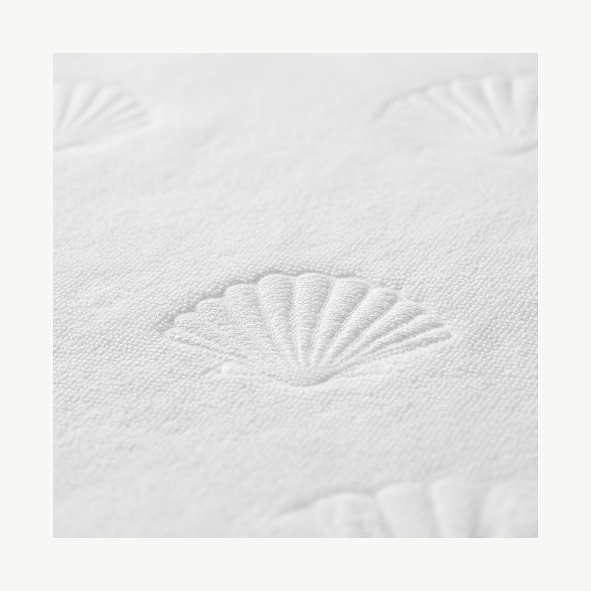 Close-up of raised shell jacquard pattern on cream cotton terry cloth fabric