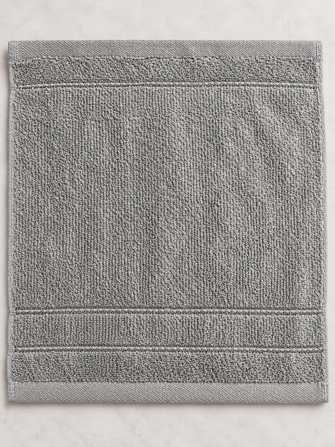 Close-up of the subtle woven bands and texture on a medium gray Design Republique face cloth