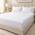 Premium white Egyptian cotton bedsheet neatly tucked on a super king bed with matching pillow covers