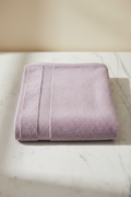 Purple Bath Towel folded flat on marble surface