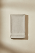 Creamish Grey Bath Towel folded flat on marble surface