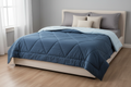 Sky blue and dark blue reversible quilted duvet styled on a bed