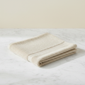 Cream face towel folded flat on marble surface