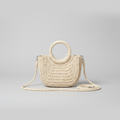 Cream woven straw crossbody bag with round rope ring handles on a light gray studio background