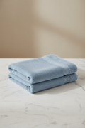 Light Blue Cotton Bath Towel folded flat on marble surface
