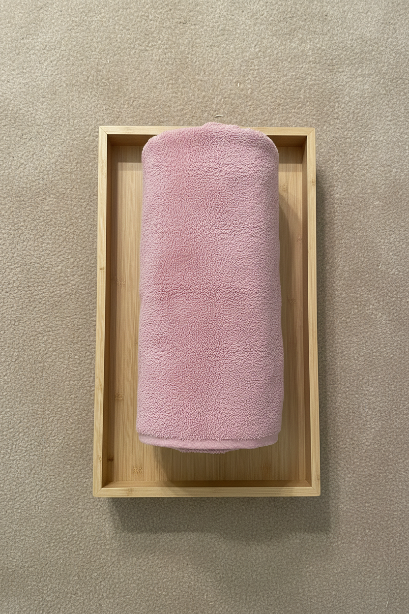 Pink Bath Towel rolled on wooden tray