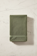 Dark Green Bath Towel folded flat on marble surface