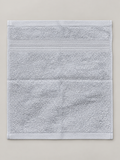 Light gray face towel with subtle woven bands and finished border measuring 28 x 30 cm