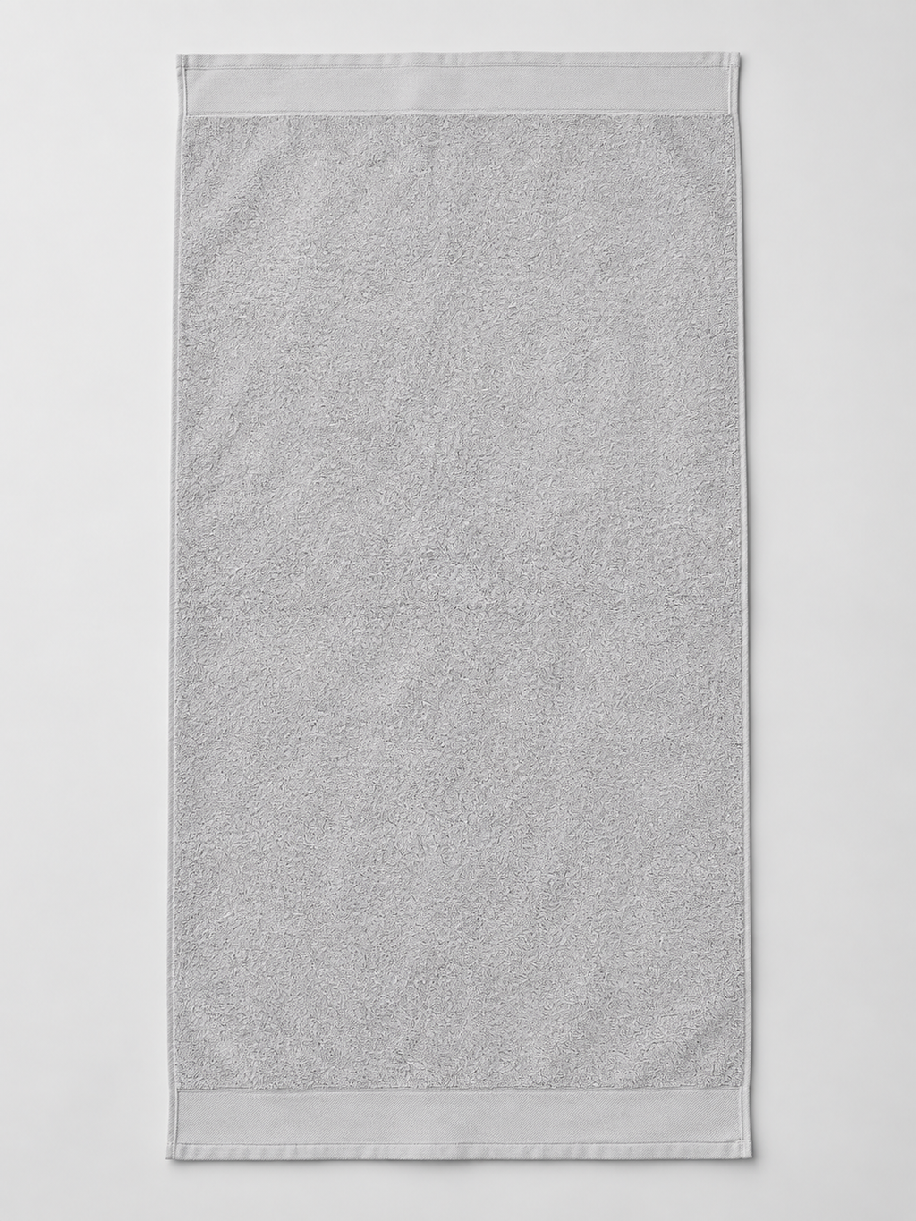 Light gray terry towel with broad woven end borders measuring 75 x 148 cm on a light gray studio background