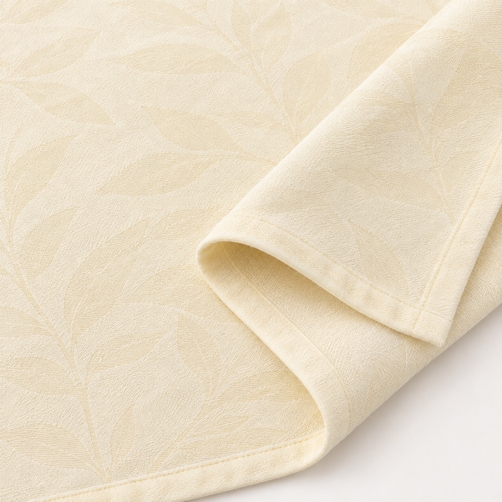 Close-up of light yellow sheet with subtle darker-tone leaf texture