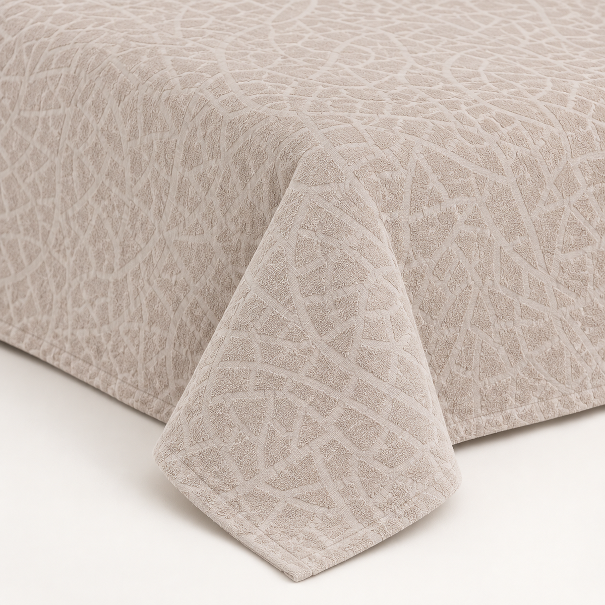 Close-up of pale beige bedspread with irregular mosaic jacquard texture