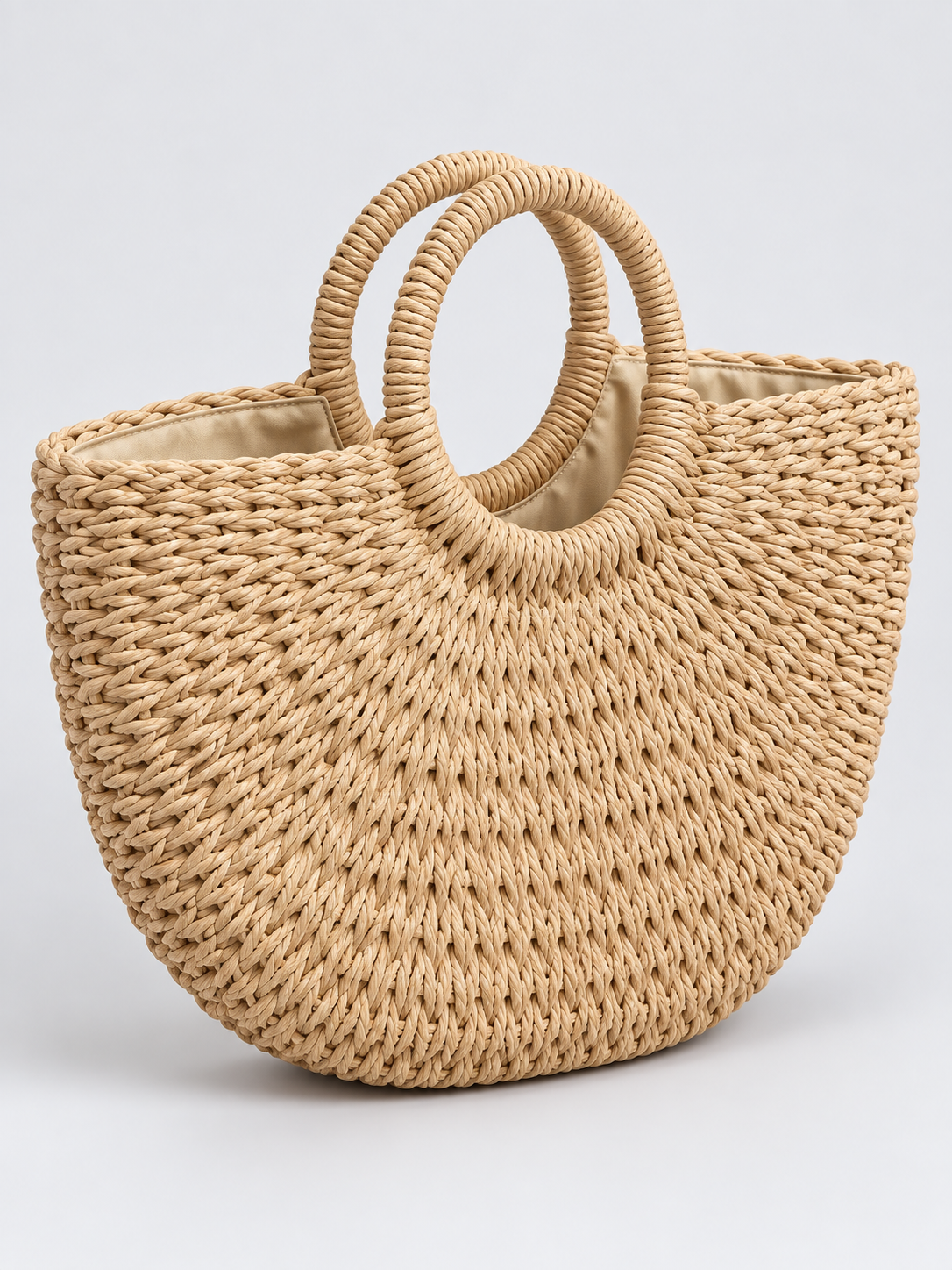 Natural braided tote bag with rope handles on a light gray studio background
